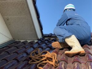 屋根を点検する職人の後ろ姿